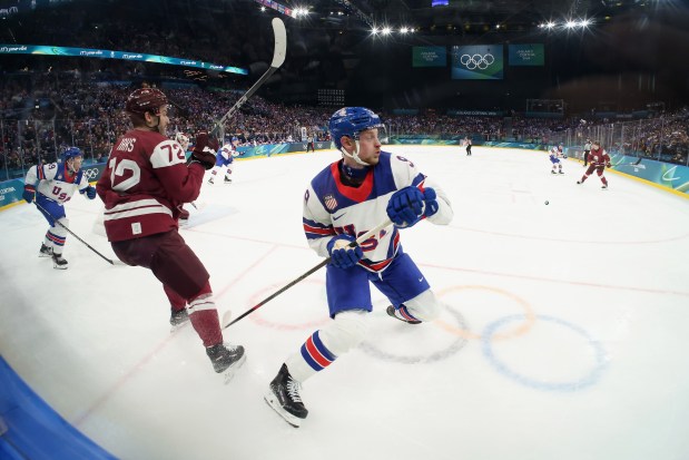 Team USA center Jack Eichel, right, a native of North Chelmsford, eyes the puck during a 5-1 win over Latvia at the Winter Olympics on Thursday. (Photo by Bruce Bennett/Getty Images)
