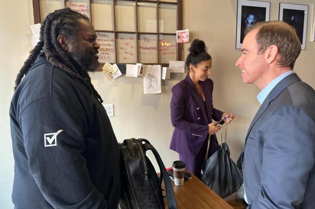 Luke Bronin, former mayor of Hartford, Conn., who is challenging Rep. John Larson, D-Conn., in the 2026 election primary, right, speaks with James Jeter, left, at the Semilla Cafe and Studio in Hartford on Jan. 22, 2026. (AP Photo/Susan Haigh)