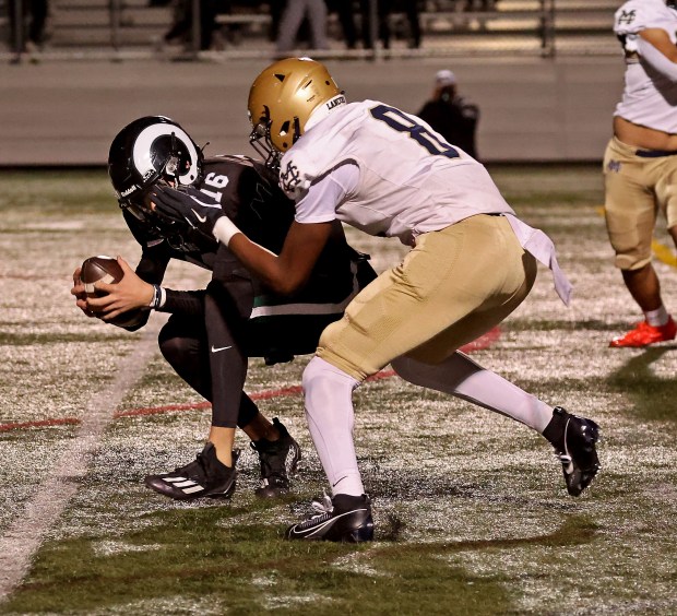 Marshifield's Nate Rollinson, left, is sacked by Malden Catholic's Jeremiah Figaro on Friday night. (Staff Photo By Stuart Cahill/Boston Herald)