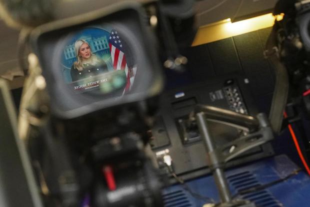 White House press secretary Karoline Leavitt is reflected in a video camera lens.