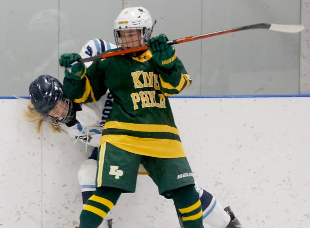 Medfield's Leah Carlson, rear, wedges herself behind King Philip's Erin Steck in an attempt to reach a loose puck during the first period last Saturday. (Photo by Paul Connors/Media News Group/Boston Herald)