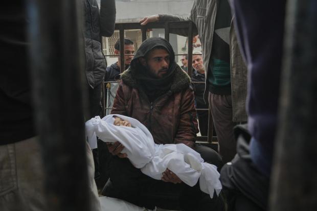 A relative holds the body of a few-months-old girl, Mira al-Khabbaz, after she was killed in an Israeli military strike, ahead of her burial at Shifa Hospital in Gaza City, Wednesday, Feb. 4, 2026. (AP Photo/Jehad Alshrafi)