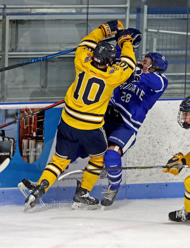 Hanover's Cam Melone (L) hits Scituate's Theodore Hare as Hanover takes on Scituate in boys hockey. (Staff photo by Stuart Cahill/Media News Group)