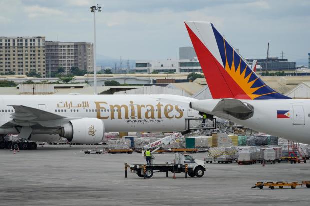 A man works beside a parked Emirates plane at Manila's International Airport.