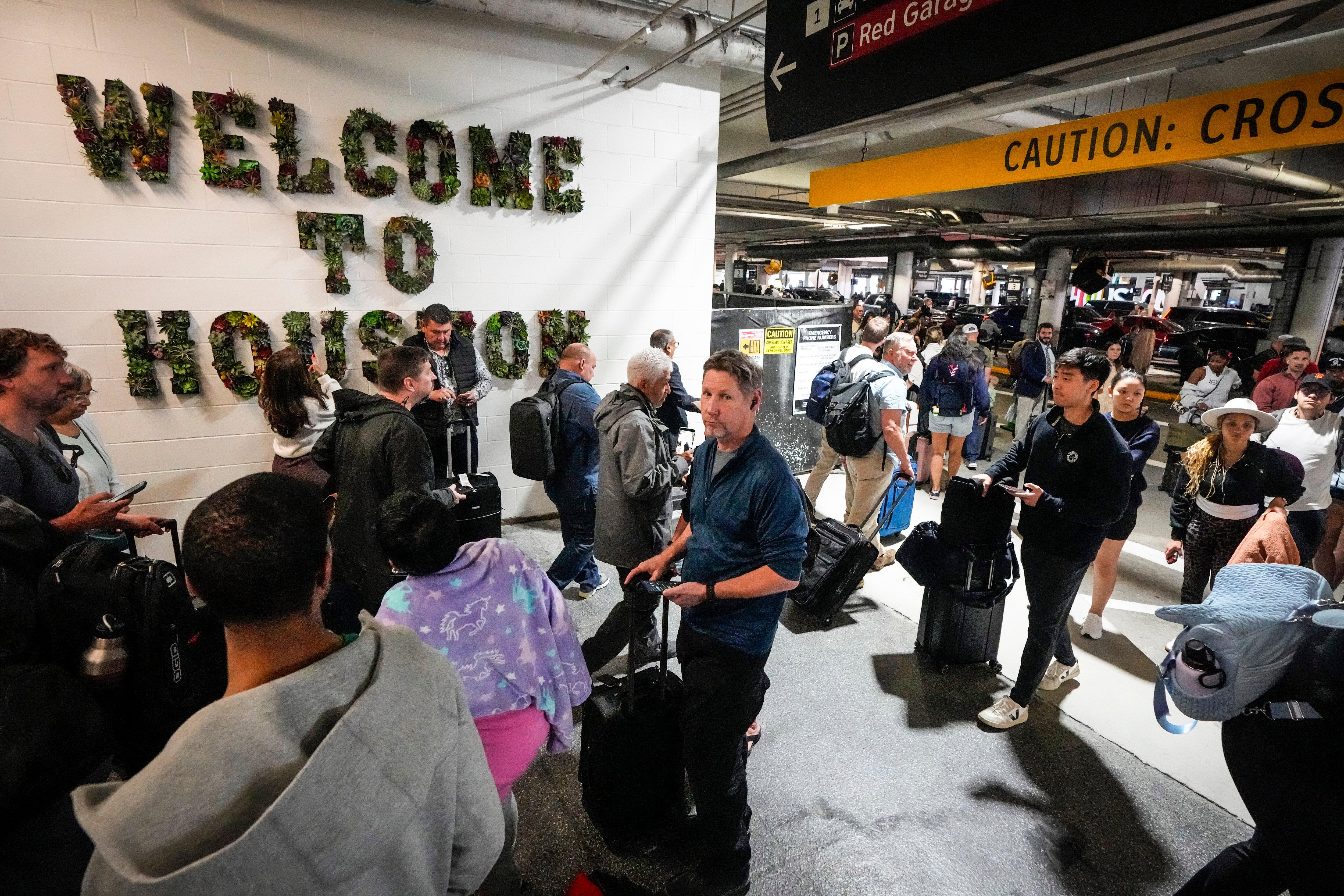 Airline passengers wait in long lines outside the terminal to get through TSA screening.