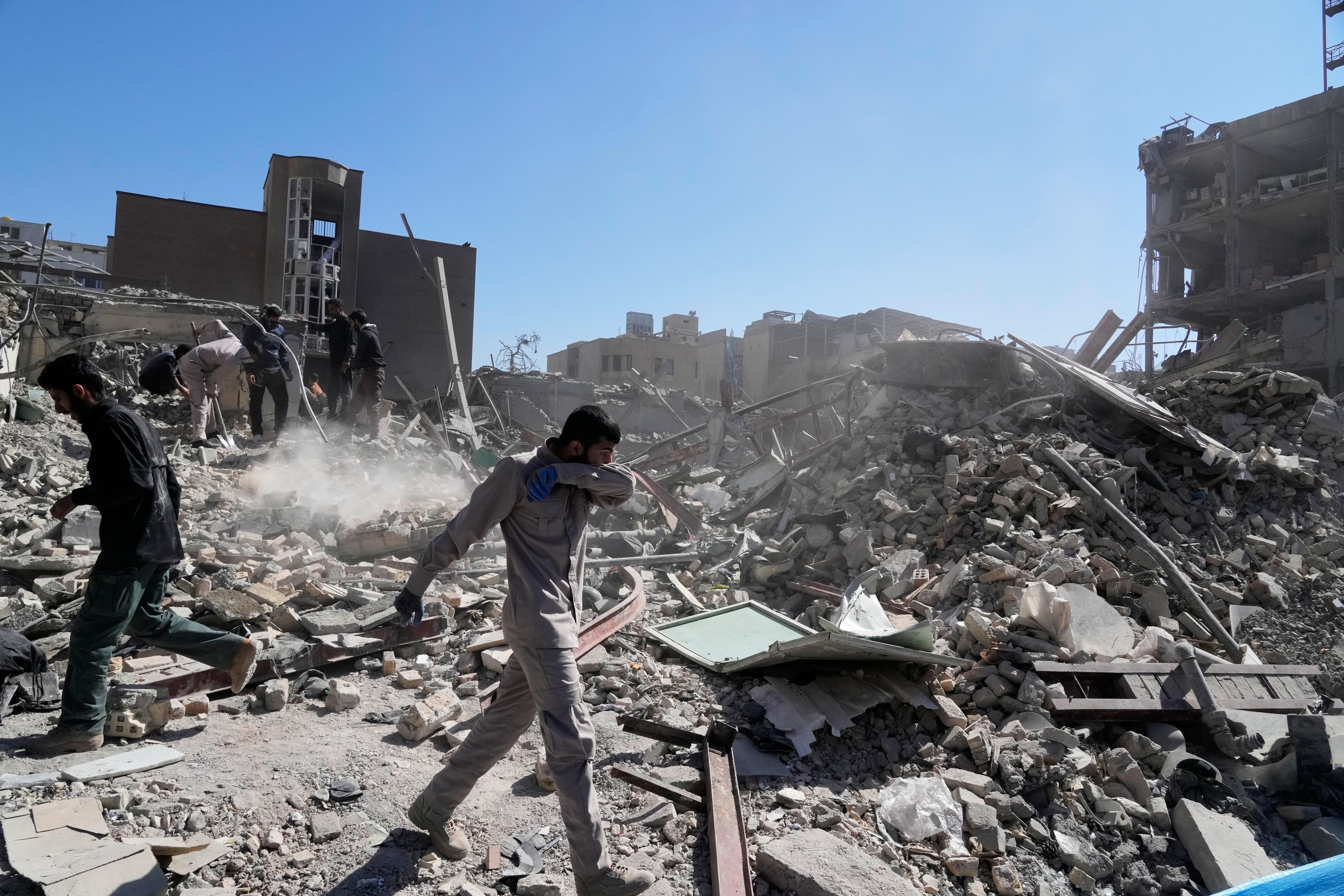 A group of men inspects the ruins of a police station struck in Tehran, Iran.