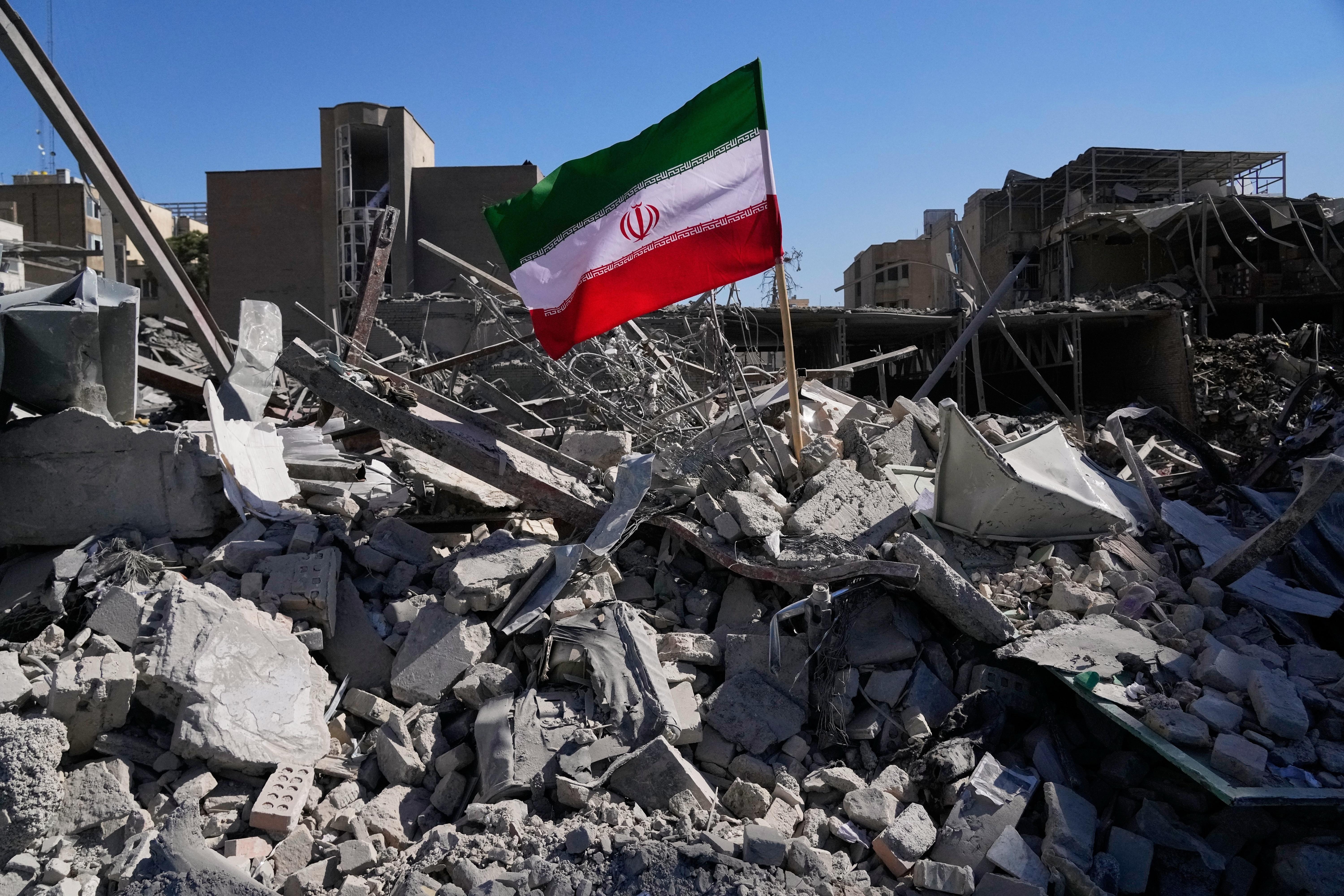 An Iranian flag is placed among the ruins of a police station struck Monday in Tehran.