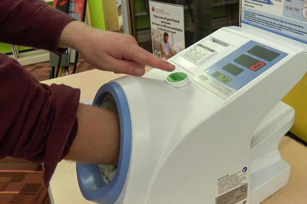A free blood pressure machine is used at the public library
