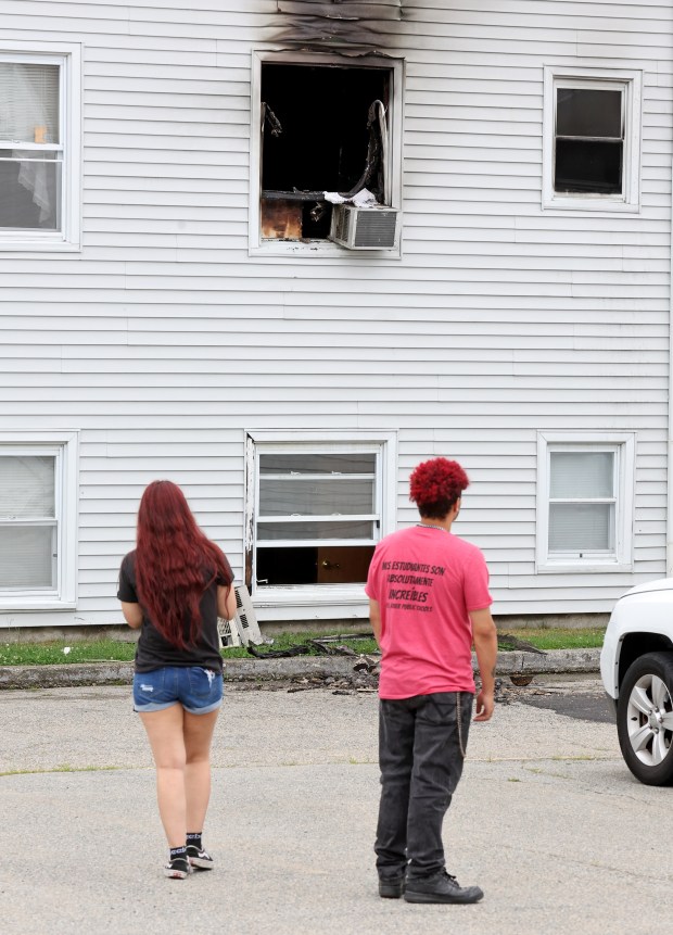 Visitors at the scene look toward a charred window at the Gabriel House assisted living home where 9 people were killed and dozens injured in a devastating fire Sunday night. (Photo By Matt Stone/Boston Herald) 