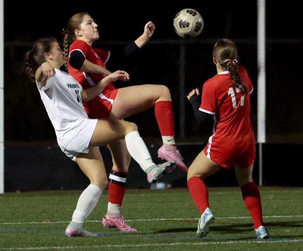 Milton's Grace Pater, center, knees the ball next to Marshfield's Charlotte Dalton, left, during the second half of a girls Div. 1 soccer match. Host Milton was a 4-1 winner. (Mark Stockwell/Boston Herald)