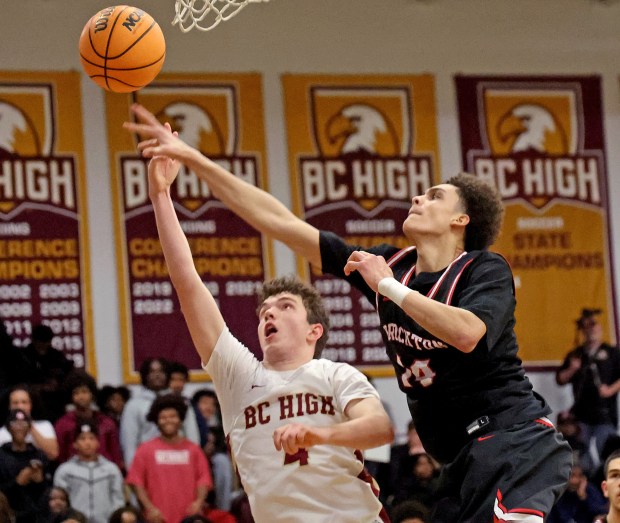 Brockton's Jayden Holes Fox swats the ball from BC High's George Bracher during the second half of a boys basketball game. (Photo By Matt Stone/Boston Herald)