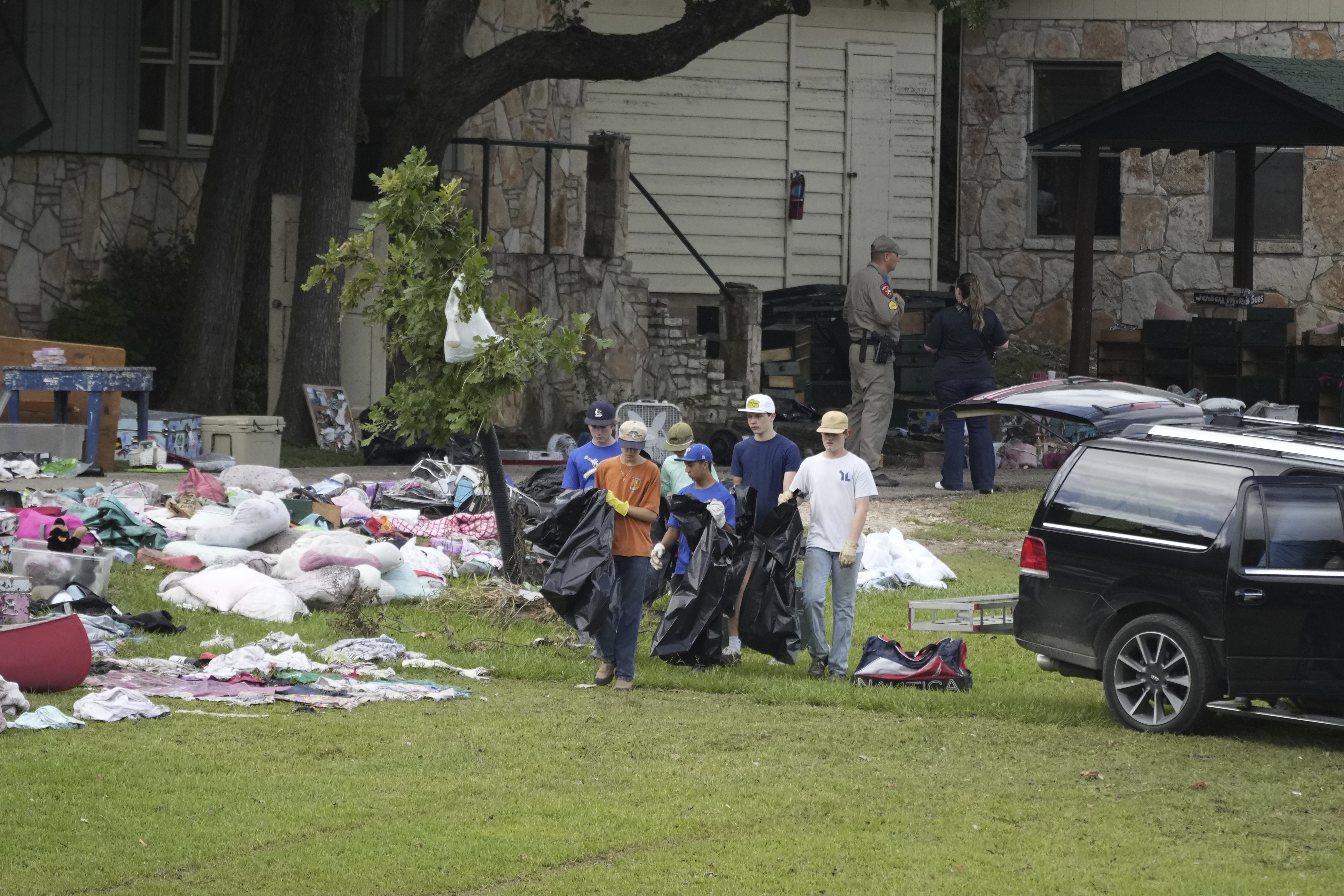 People clean up after the flood at Camp Mystic in...