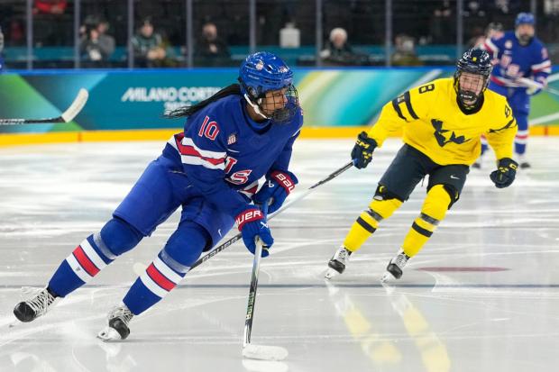 United States' Laila Edwards is challenged by Sweden's Hilda Svensson during a women's ice hockey game.