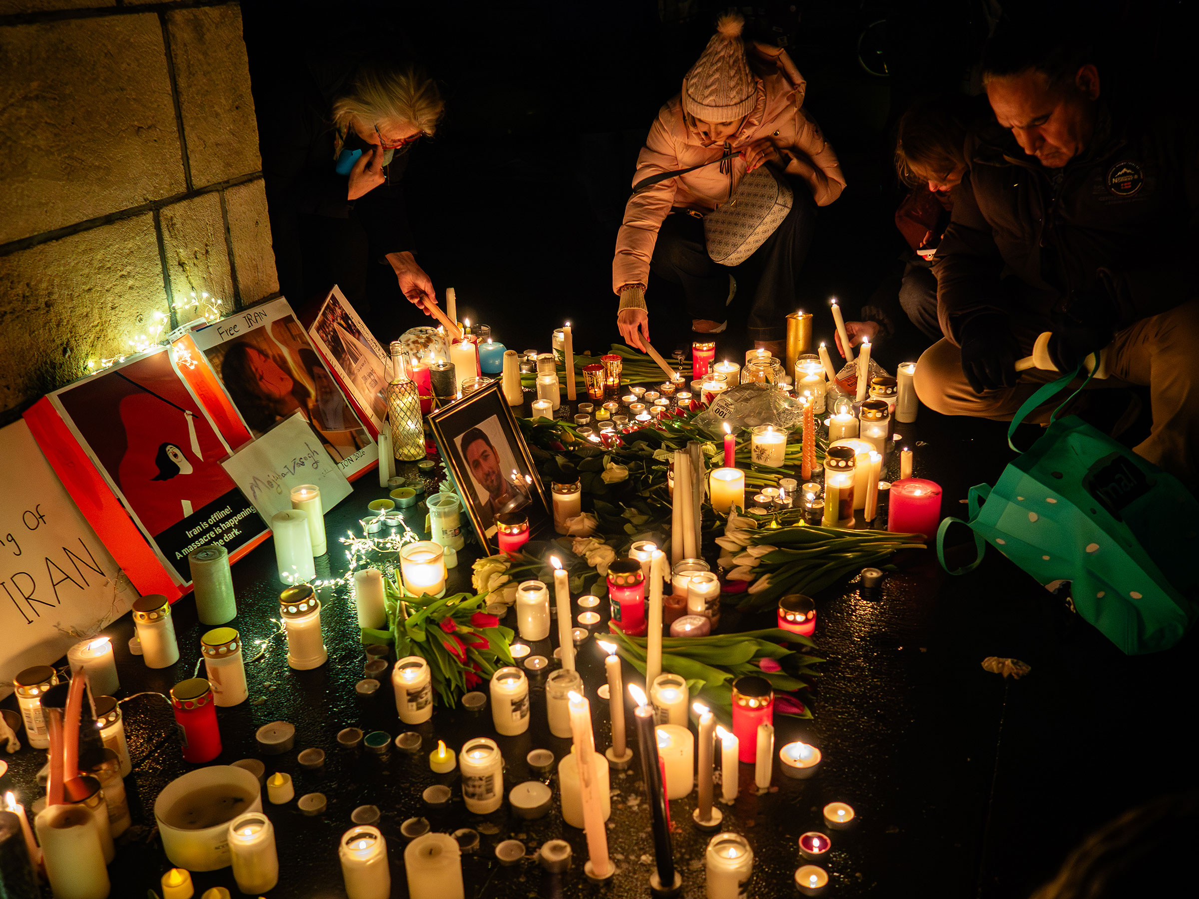People are seen lighting candles as attendees gather at
