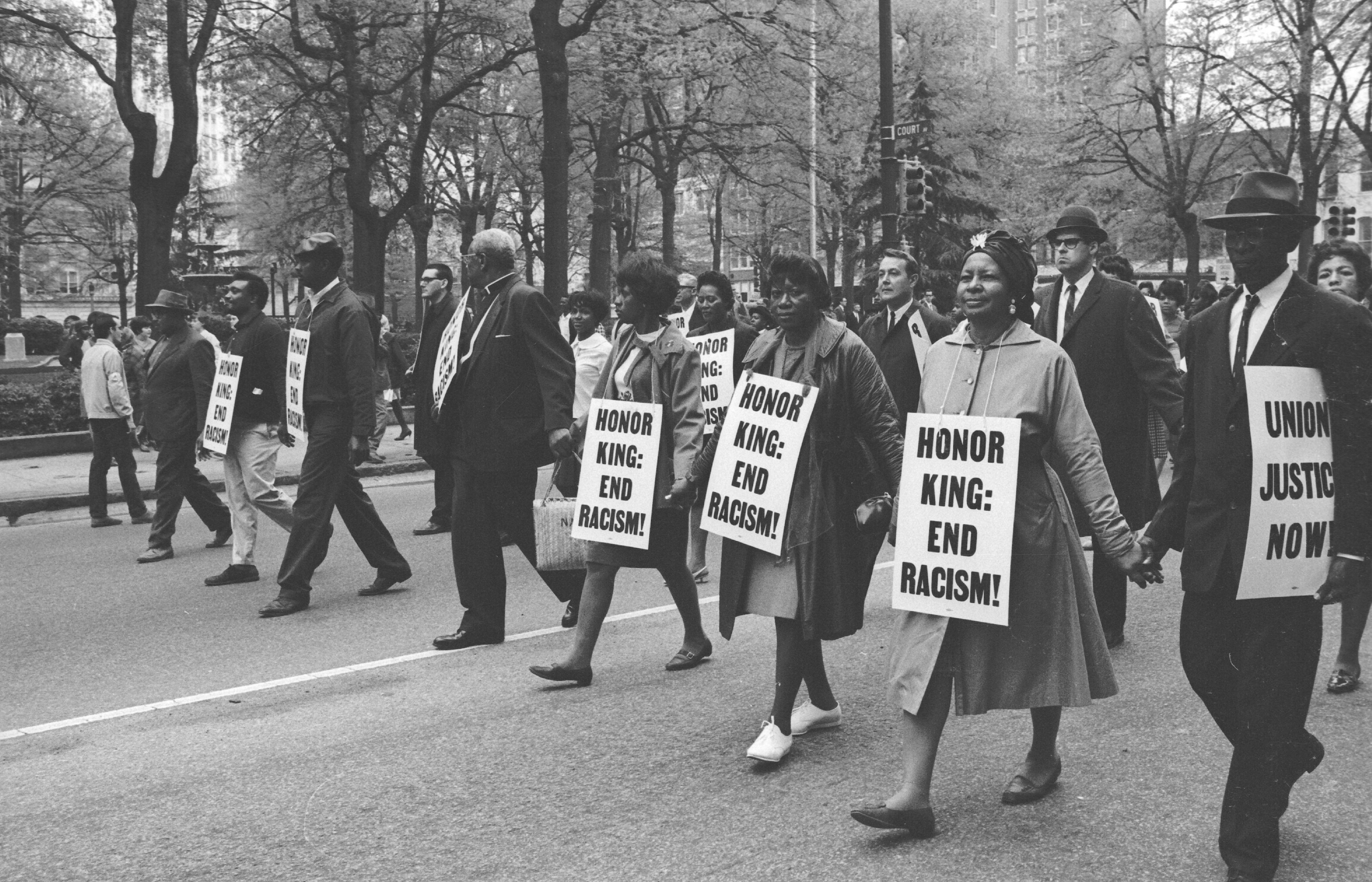Marchers wear signs that read 'Honor King: End Racism!' and 'Union Justice Now' as they participate in the Sanitation Workers march, soon after the assassination of Dr. Martin Luther King, Jr., Memphis, Tenn., April 1968.