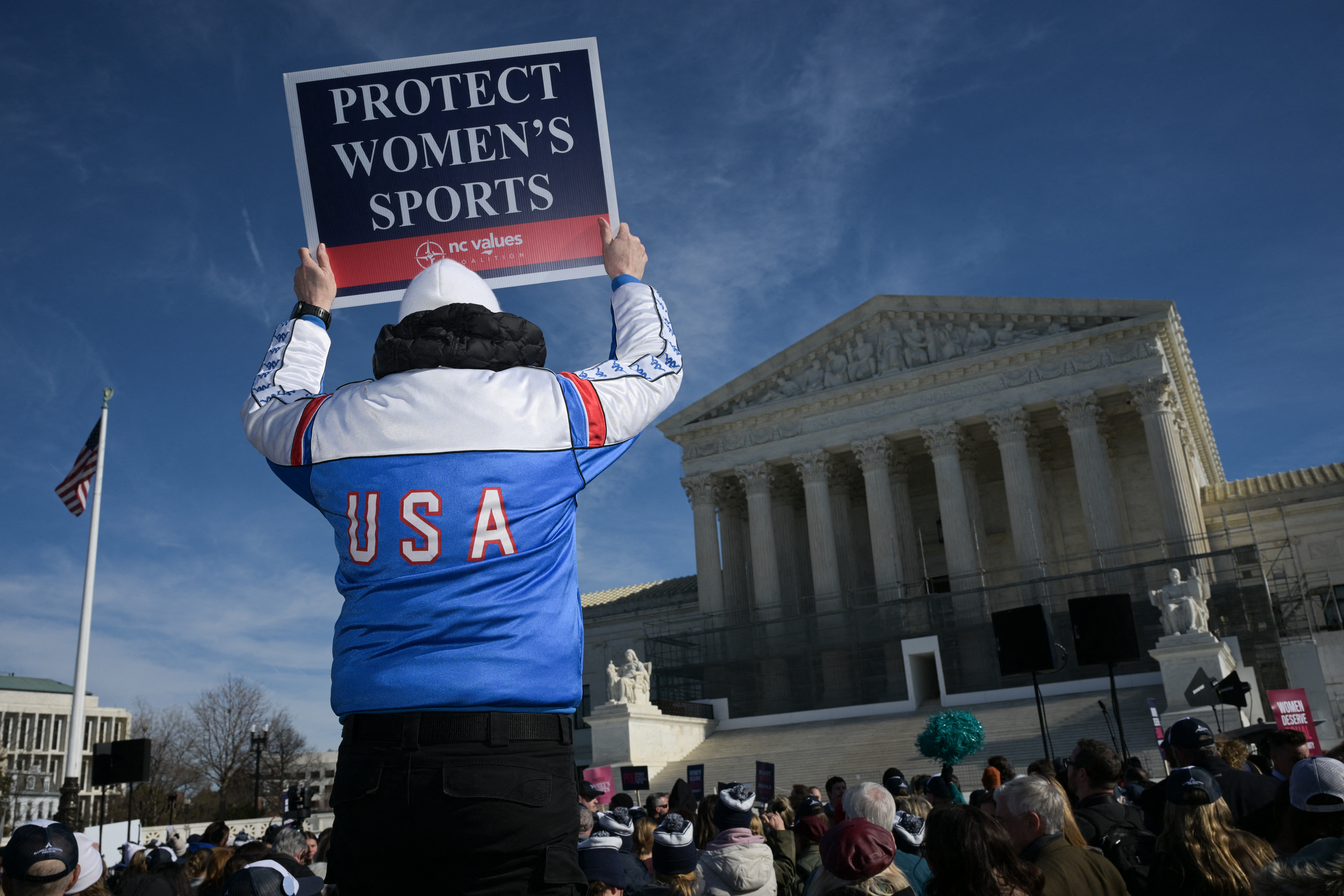 A man holds up a sign reading "Protect Women's Sports" as he demonstrates outside the U.S. Supreme Court as justices hear arguments in challenges to state bans on transgender athletes in women's sports on Jan. 13, 2026, in Washington, D.C.