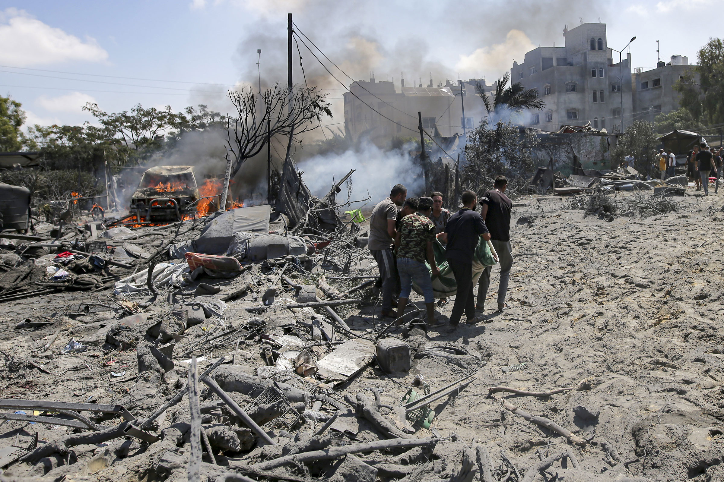 \Palestinians evacuate a body from a site hit by an Israeli bombardment on Khan Younis, southern Gaza Strip, on July 13, 2024.