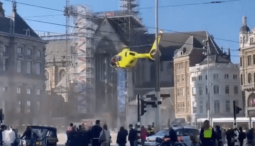 Helicopter flying over a city street.