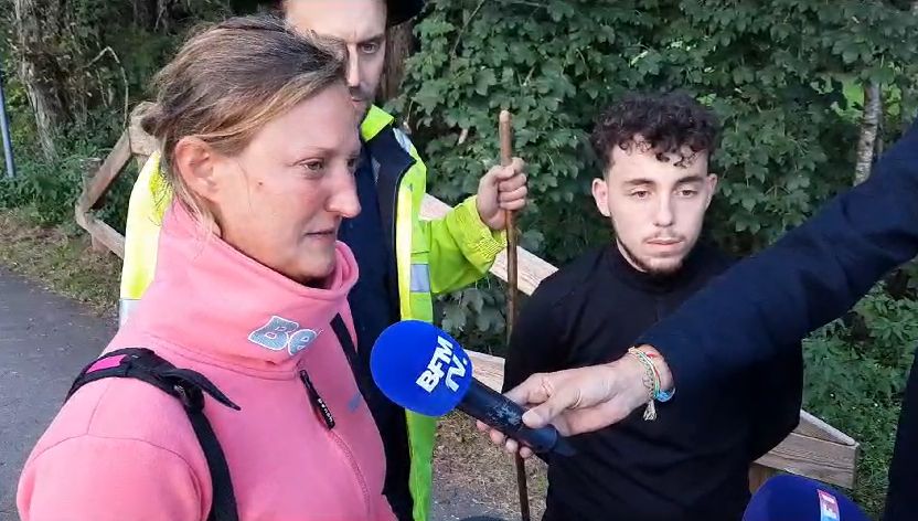 a woman in a pink sweatshirt is being interviewed by a man holding a microphone .