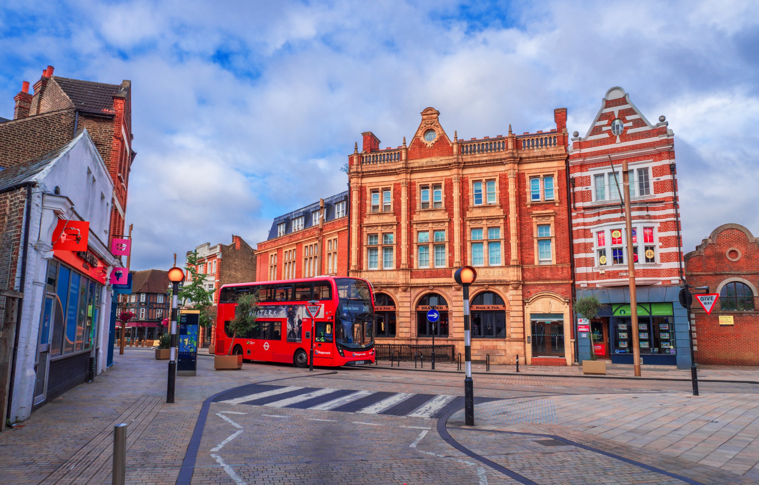 Bromley Borough, London, England - July 21, 2024: Charming Bromley centre: A Picturesque Road with Traditional British Brick Houses, high street shops and Iconic Double-Decker Bus on East Road