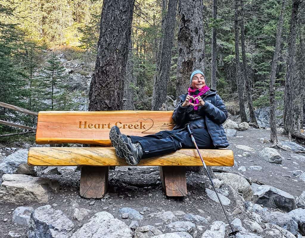 Woman sitting on a bench at the end of the Heart Creek trail in Kananaskis