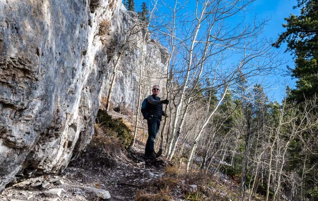 A man along the trail beside the White Buddha climbing crag near Bragg Creek