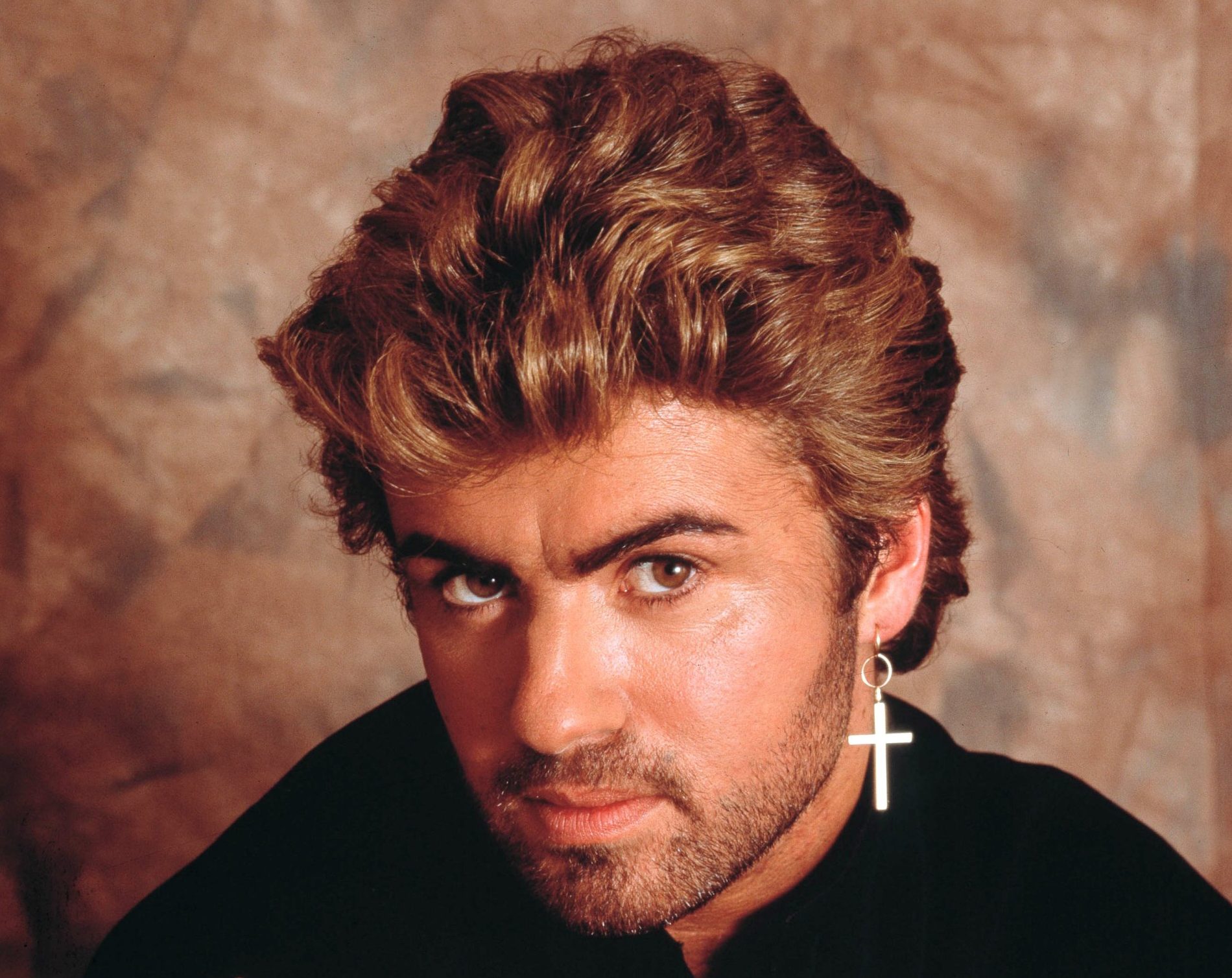 George Michael, studio portrait, London, 1987. (Photo by Michael Putland/Getty Images)