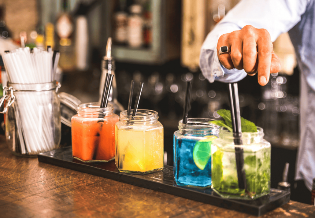 Bartender hand at multicolored fashion drinks