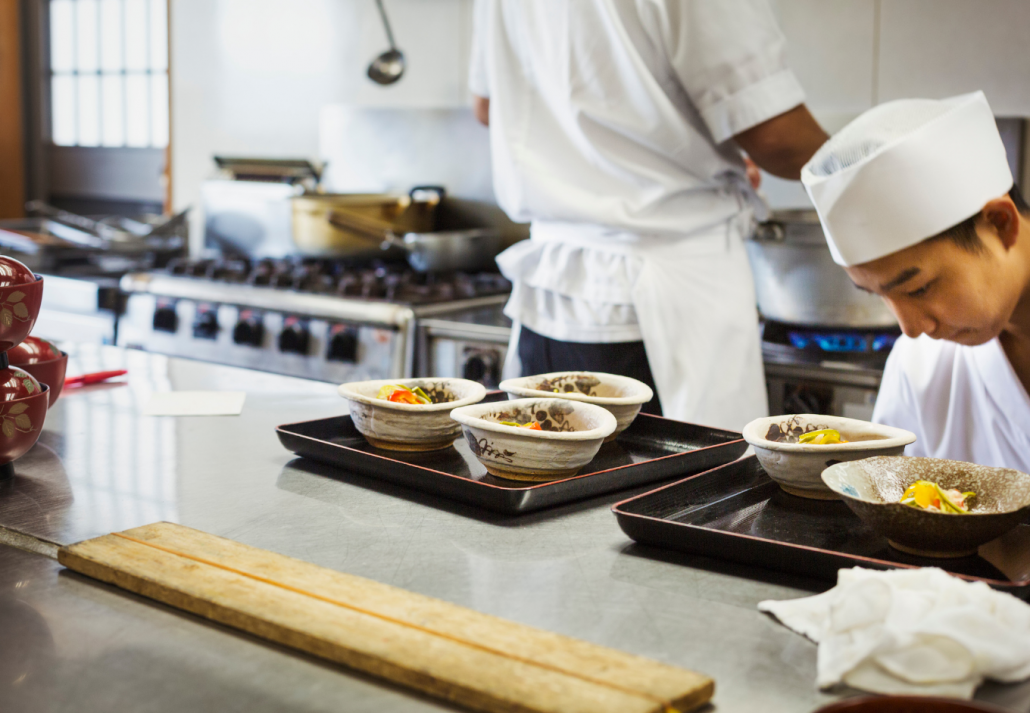 Two chefs working at a counter at a Japanese sushi restaurant.