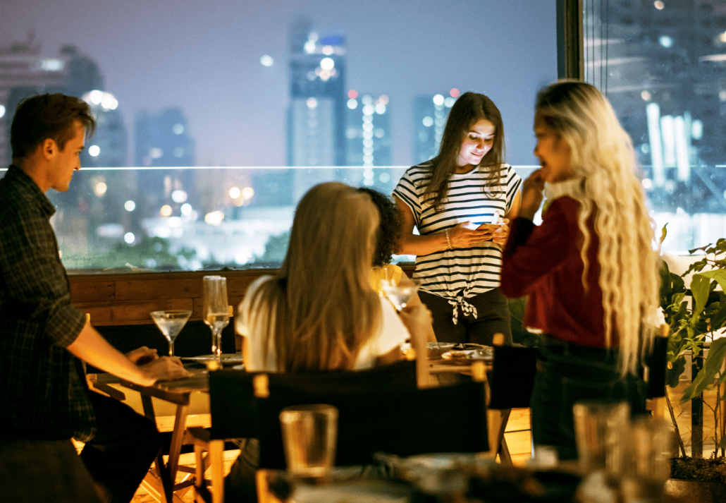 Young woman using a smartphone at a dinner night