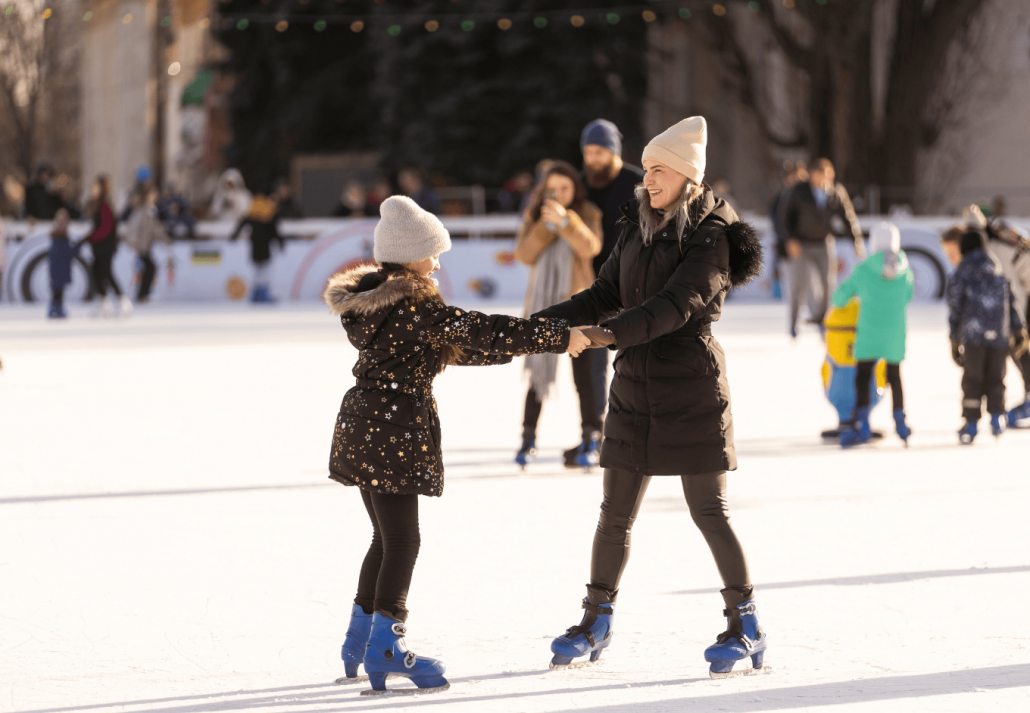 Mother and daughter skating on ice.